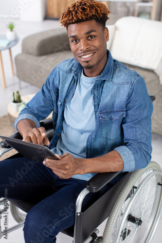 cheerful handsome wheelchaired blogger surfing the net photo