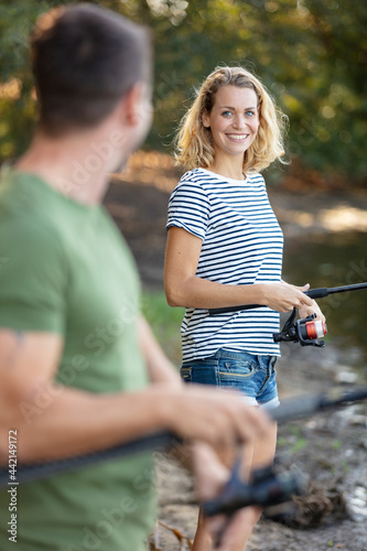 young couple is enjoying fishing on sunny day
