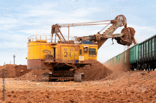 large excavator loads rock with iron or bauxite mining