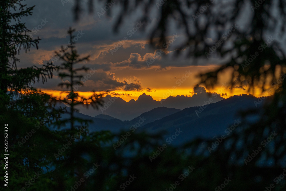 storm clouds at the sky in the golden sunset with view to the alps, the wilder kaiser in tirol, austria