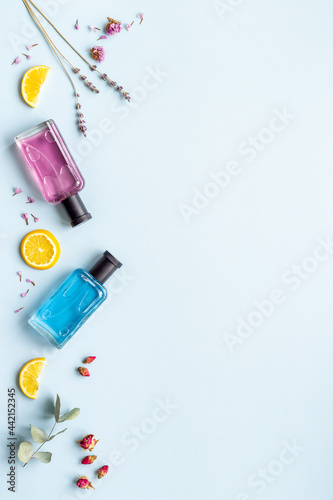 Perfume bottles with leaves and fruits, top view
