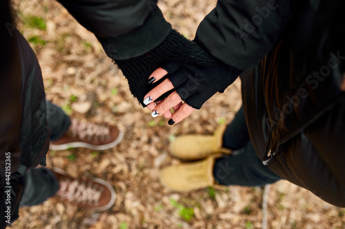 Modern young couple holding hands while standing in the woods outdoor travel concept
