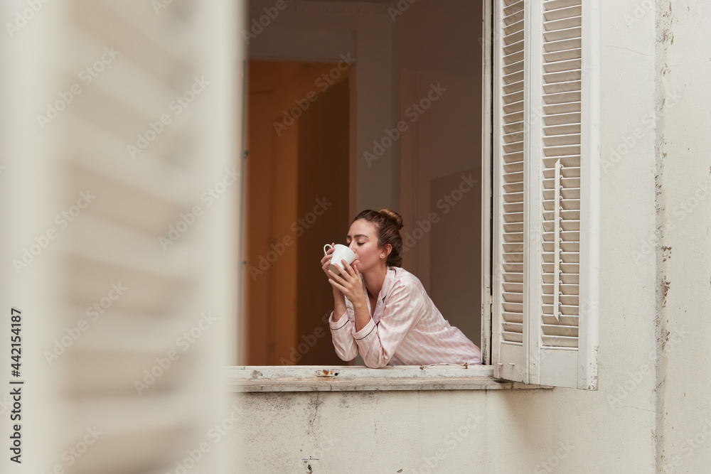 Woman drinking beverage in window Woman drinking beverage in window