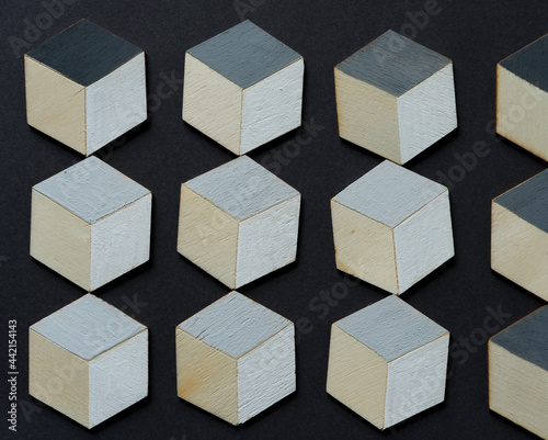 hand painted hexagons in gray and white or trompe l'oeil cubes loosely arranged on dark gray paper background