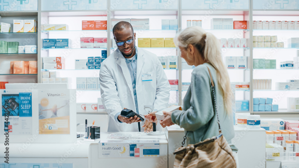 Pharmacy Drugstore Checkout Counter: Professional Black Pharmacist Sells Medicine to Diverse Group of Multi-Ethnic Customers, they Pay Using Contactless Payment Credit Card to Buy Drugs, Vitamins