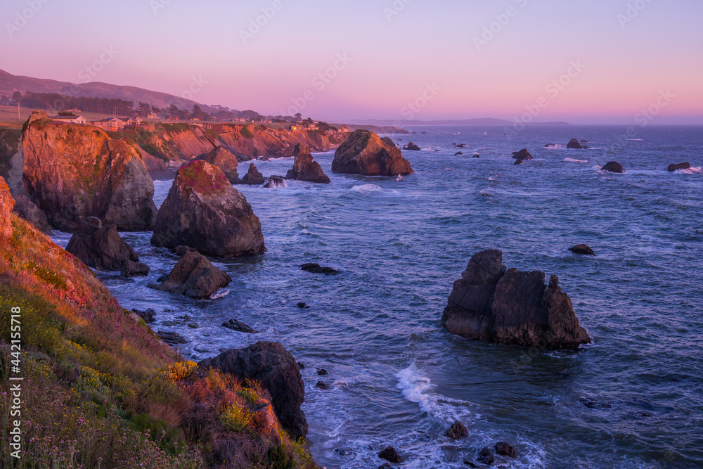 Marvelous sunset, amazing evening sky. Large boulder among the waves in the sea. Sonoma Coast State Park, California, USA