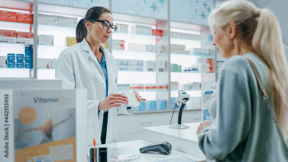 Obraz premium Pharmacy Drugstore Checkout Cashier Counter: Female Pharmacist Explains Use and Manual for Prescription Medicine Beautiful Senior Female Customer Paying Using Contactless Credit Card to Terminal