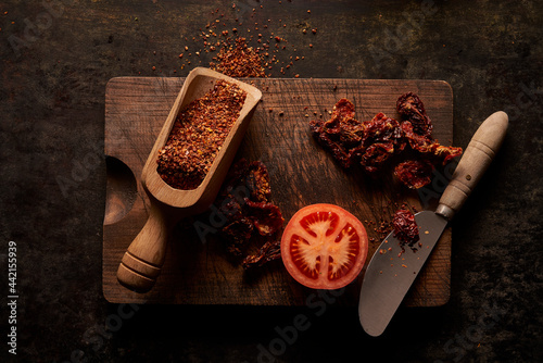 Fresh and dried tomato on wooden board photo