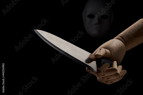 Anonymous person in mask with wooden hand with sharp knife photo