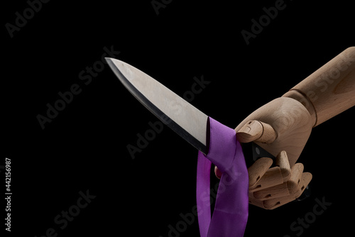 Crop wooden hand with sharp knife in studio photo