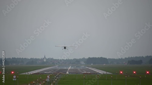Ultralight small passenger airplane landing on the runway. Ljubljana airport, Slovenia. Aircraft landing. Small generic private propeller airplane on landing strip. Static shot, real time