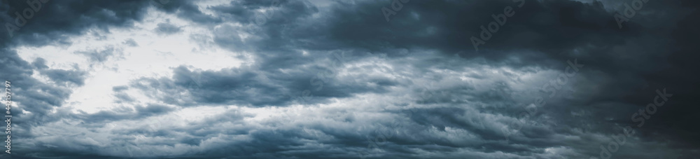 Dark cloudy sky before thunderstorm panoramic background. Storm panorama, Panorama view of overcast sky. Dramatic gray sky and white clouds background Storm sky. Cloud.