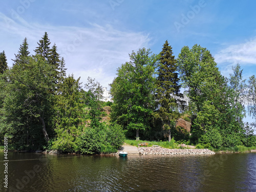 View from the shore of the Vyborg Bay to the island with a Chapel and a grotto in the Monrepos rock Natural Park of the city of Vyborg on a clear summer day