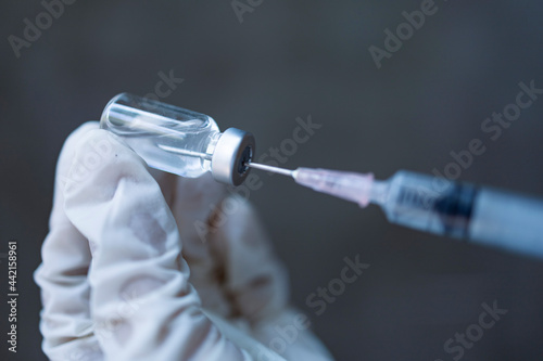 Doctor holding vaccine and syringe ready to inject