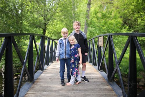 Cute Little Kids Standing on Bridge Smiling photo