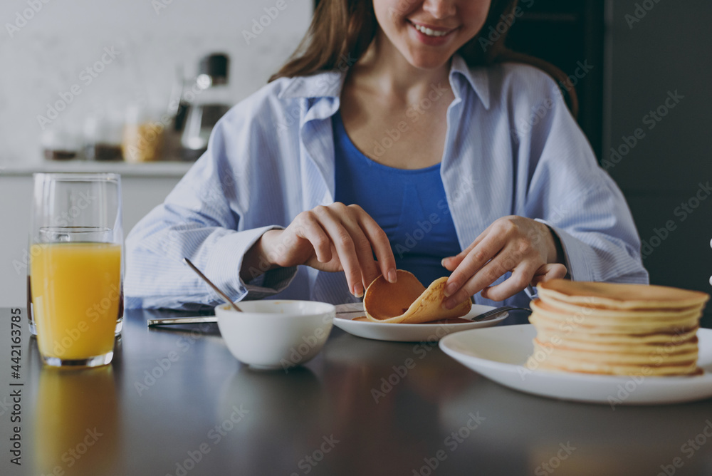 Cropped up shot photo young housewife woman 20s wearing casual clothes blue shirt eating breakfast pancakes with maple syrup cooking food in light kitchen at home alone Healthy diet lifestyle concept Cropped up shot photo young housewife woman 20s wearing casual clothes blue shirt eating breakfast pancakes with maple syrup cooking food in light kitchen at home alone Healthy diet lifestyle concept