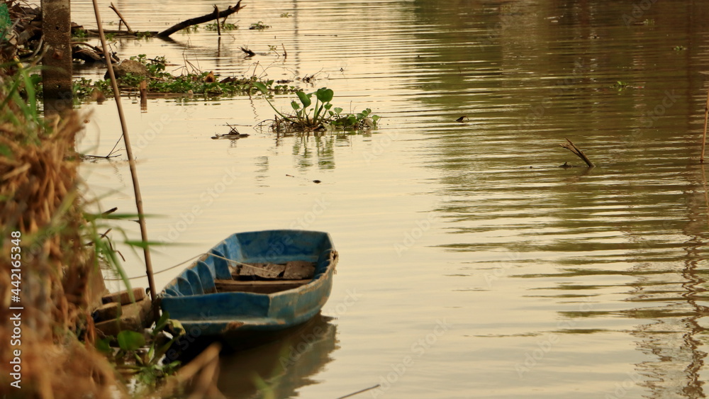 The blue boat floats in the canal. The blue boat floats in the canal.