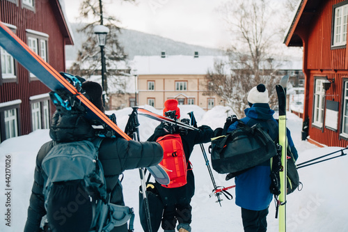 Vänner går med utrustning i skidort photo