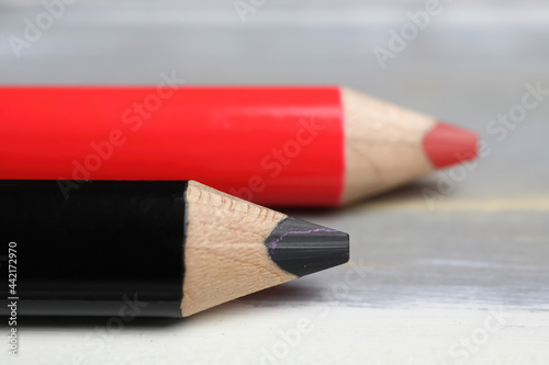 Принти на полотні Closeup of isolated colorful black and red crayons on wood background - grand co