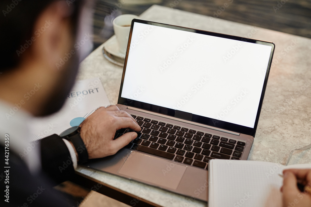 High angle close up of successful businessman using laptop with blank white screen while working in hotel lobby, copy space High angle close up of successful businessman using laptop with blank white screen while working in hotel lobby, copy space