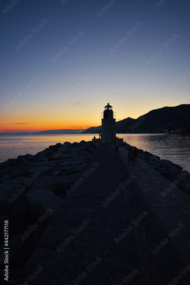 view of the lighthouse in Camogli with amazing sunset over the sea