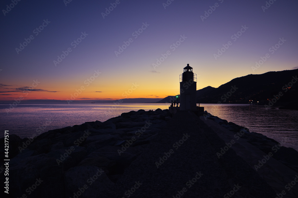 view of the lighthouse in Camogli with amazing sunset over the sea
