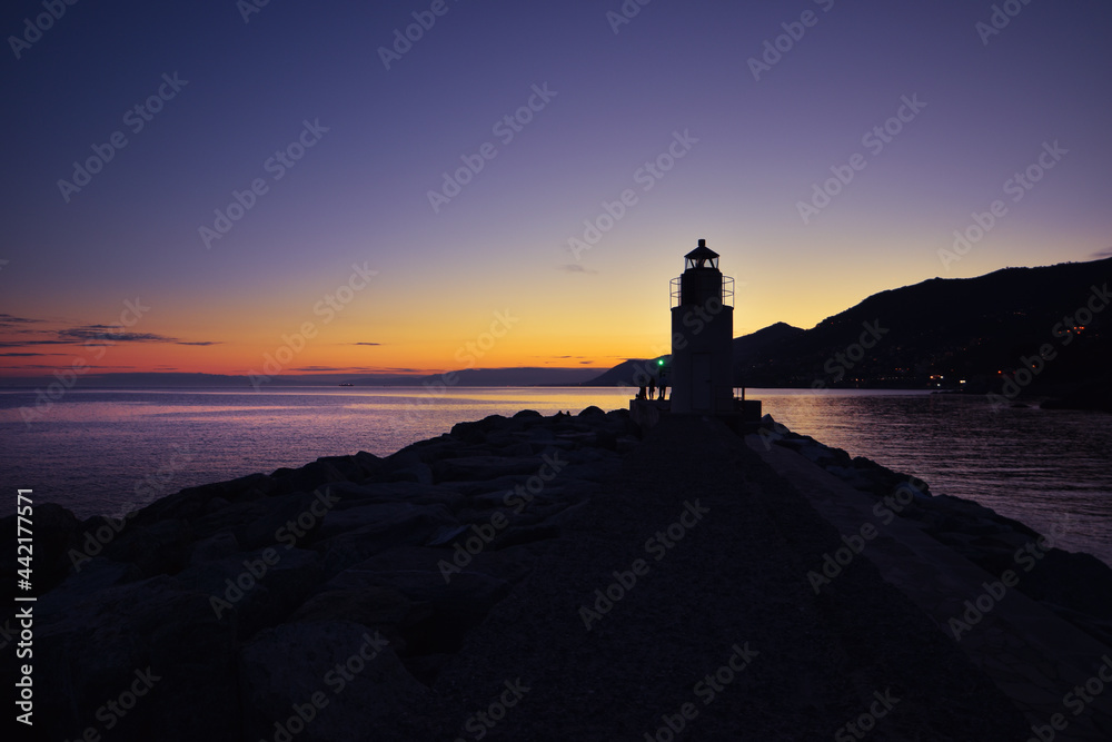 view of the lighthouse in Camogli with amazing sunset over the sea view of the lighthouse in Camogli with amazing sunset over the sea