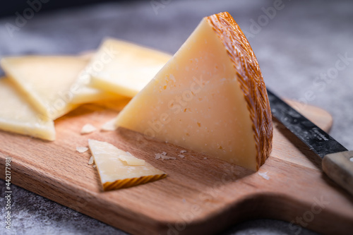 Foto Closeup shot of triangle pieces of cured Manchego cheese and a sharp knife on a