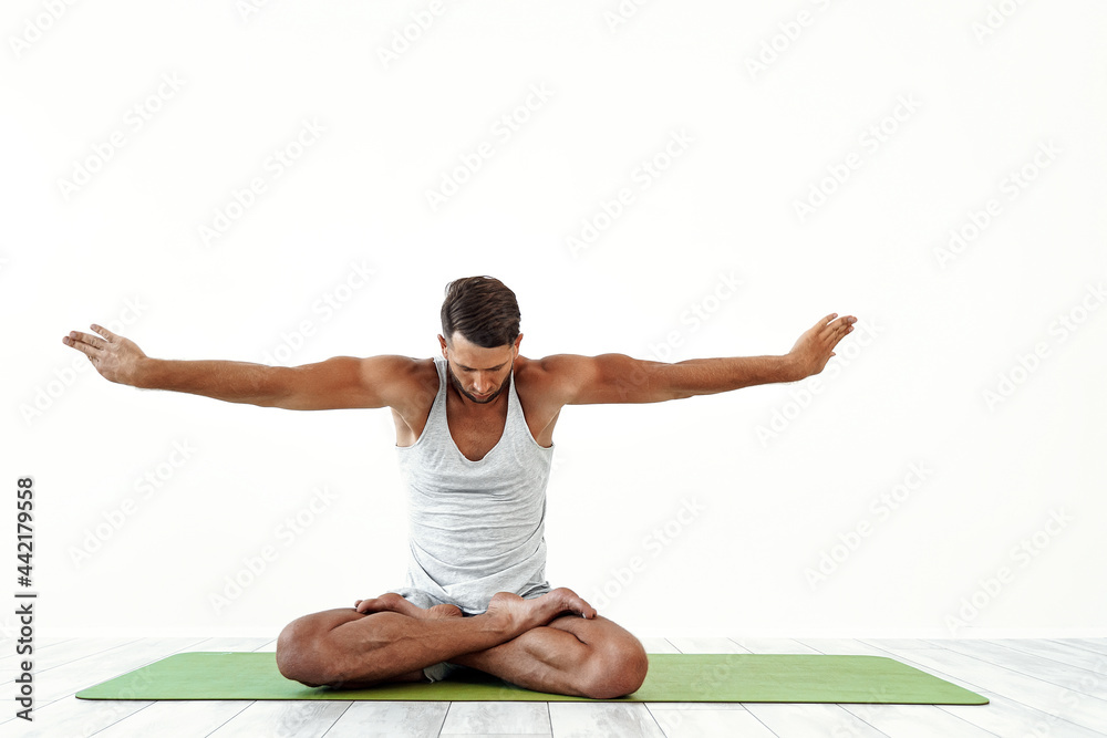 Male yoga maditates in classical pose in studio over white background Male yoga maditates in classical pose in studio over white background