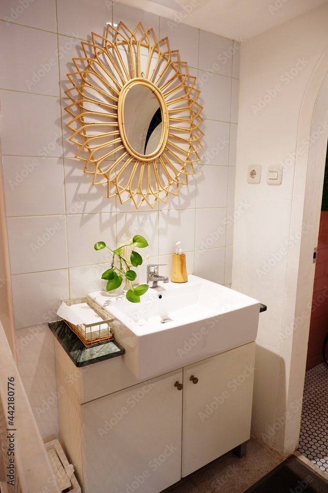 Simple powder room with vanity sink. There is rattan bamboo mirror on ...
