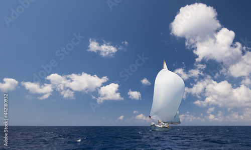 Sailboat with white spinnaker sailing downwind