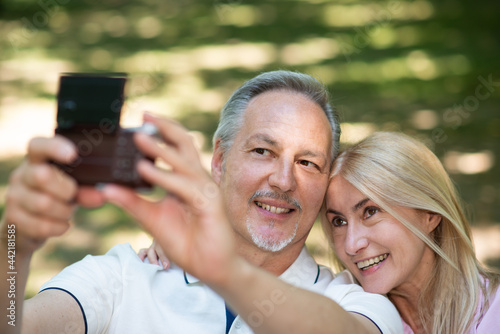Mature couple taking a self portrait in a park