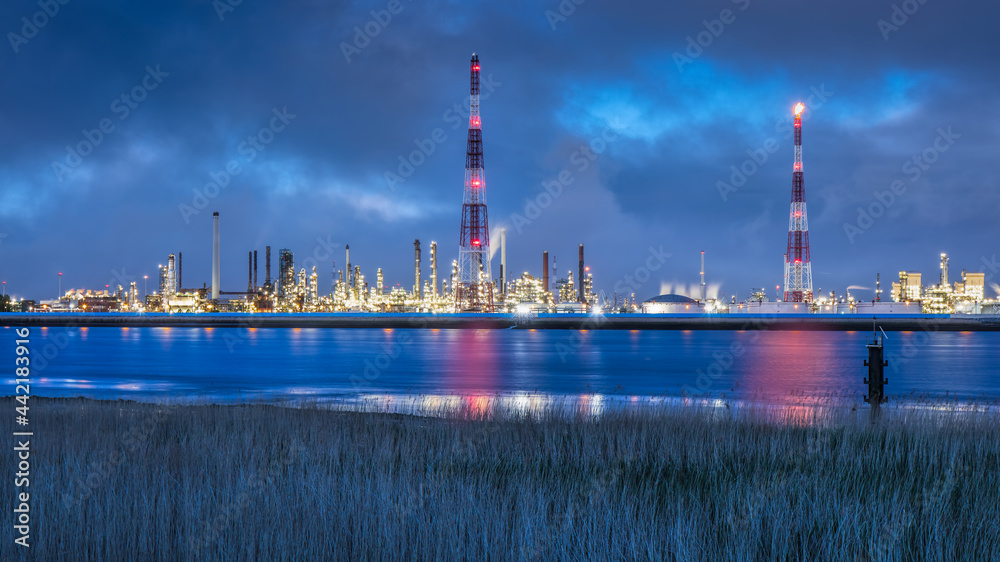 View on large petrochemical production plant on riverbank at twilight, Port of Antwerp