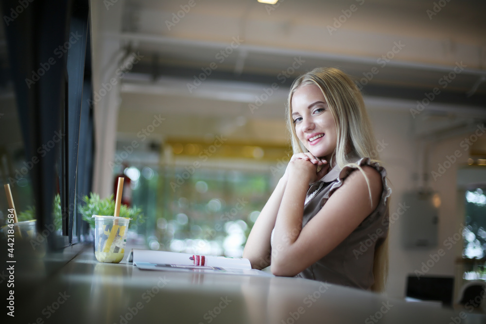 Portrait of young beautiful woman blonde hair sitting against in cafe, copy space Portrait of young beautiful woman blonde hair sitting against in cafe, copy space