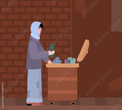 Homeless poor sad hungry person search for food in street garbage can.