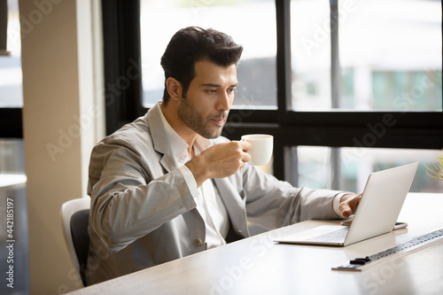 businessman working on laptop while drinking coffee in the office.