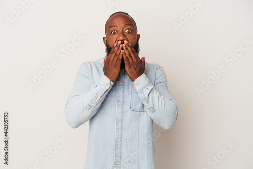 African american man with beard isolated on pink background shocked covering mouth with hands.