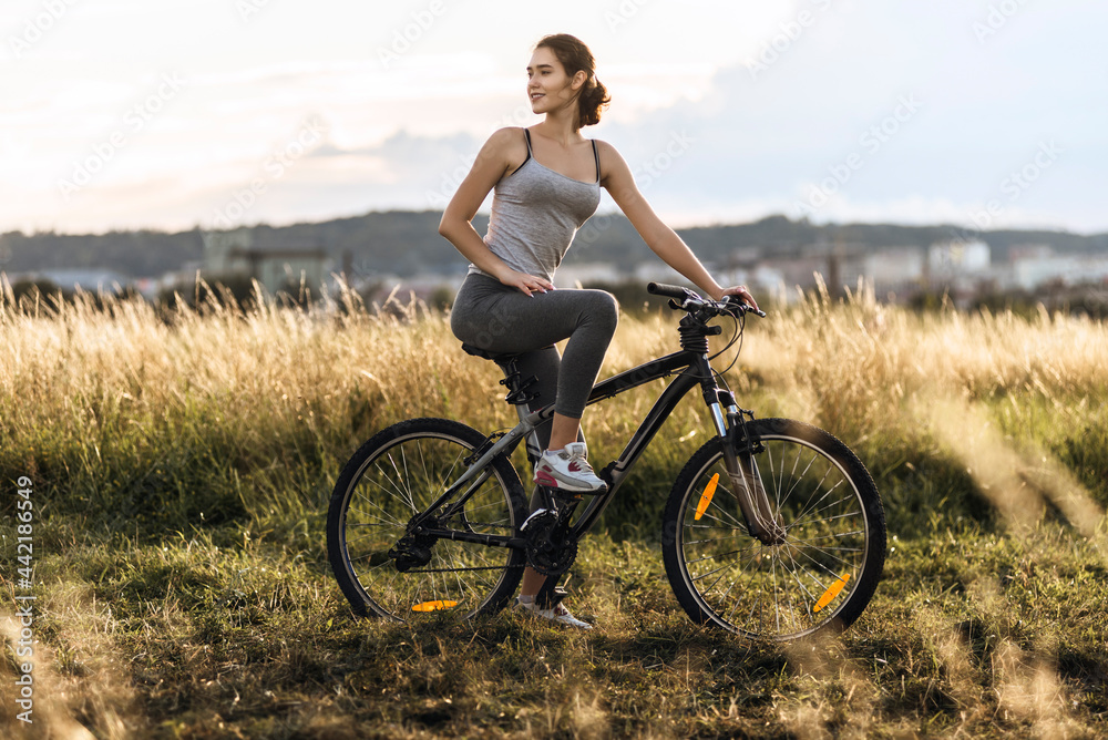 Fitness girl in sport clothes riding a bicycle outdoor Fitness girl in sport clothes riding a bicycle outdoor