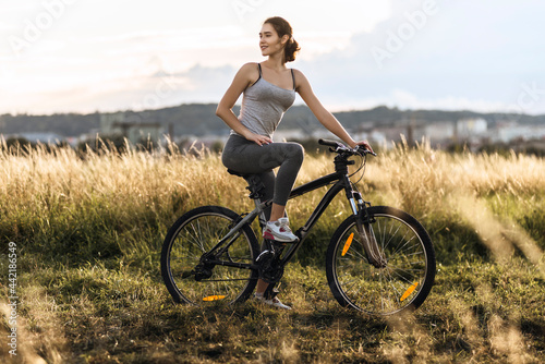 Fitness girl in sport clothes riding a bicycle outdoor