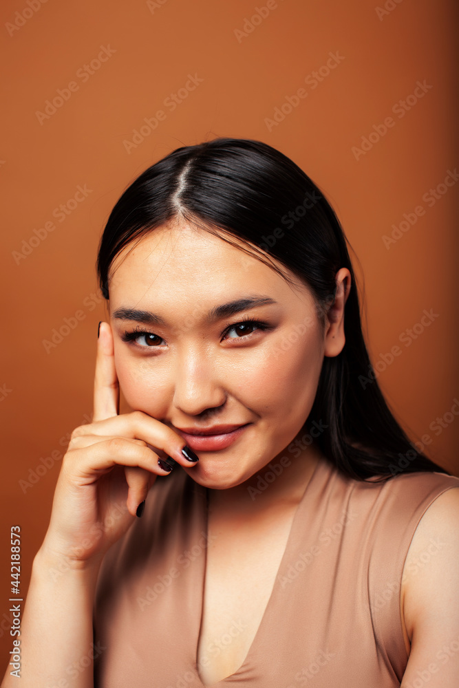 young pretty asian woman cheerful smiling posing on warm brown background, lifestyle people concept young pretty asian woman cheerful smiling posing on warm brown background, lifestyle people concept