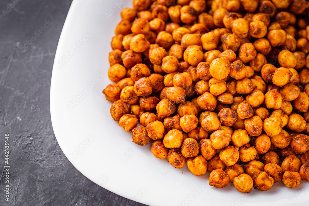 fried chickpeas on a dark stone background fried chickpeas on a dark stone background