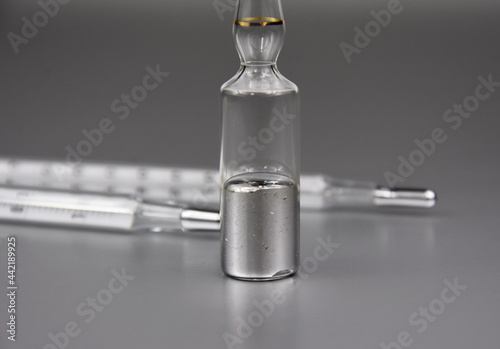 Mercury chemical element stock images. Laboratory accessories images. Mercury in a sealed ampoule stock photo. Laboratory equipment on a silver background. Hg, toxic chemical element stock images photo