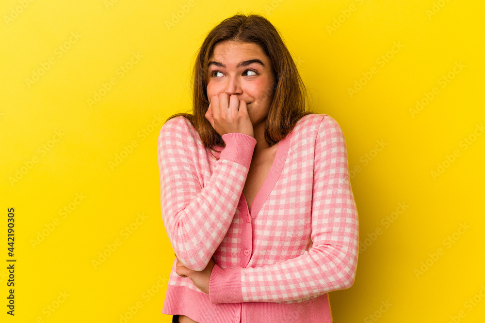 Young caucasian woman isolated on yellow background biting fingernails, nervous and very anxious. Young caucasian woman isolated on yellow background biting fingernails, nervous and very anxious.