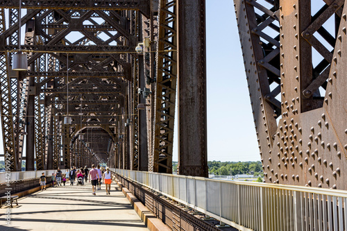 Close-up of the infrastructure of the pedestrian bridge from Louisville, Kentucky to Jeffersonville, Indiana over the Ohio River with people walking on the bridge. photo