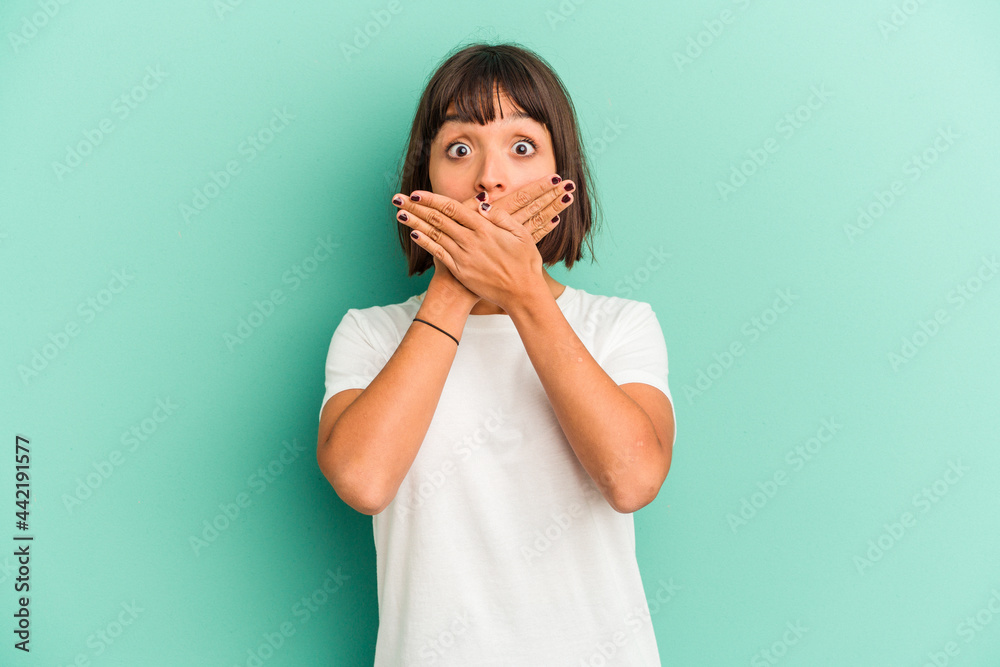 Young mixed race woman isolated on blue shocked covering mouth with hands. Young mixed race woman isolated on blue shocked covering mouth with hands.