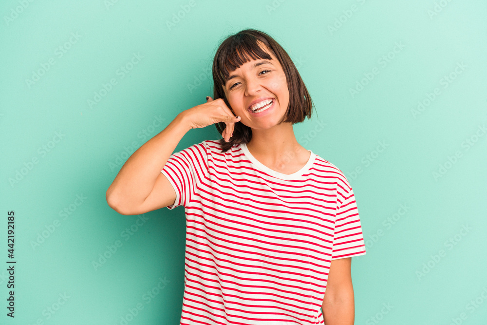 Young mixed race woman isolated on blue showing a mobile phone call gesture with fingers. Young mixed race woman isolated on blue showing a mobile phone call gesture with fingers.