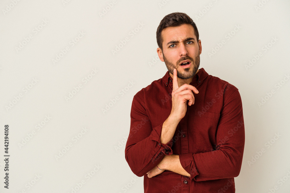 Young caucasian man isolated on white background looking sideways with doubtful and skeptical expression. Young caucasian man isolated on white background looking sideways with doubtful and skeptical expression.
