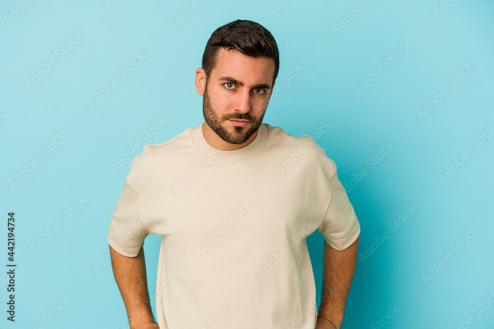 Young caucasian man isolated on blue background sad, serious face, feeling miserable and displeased.