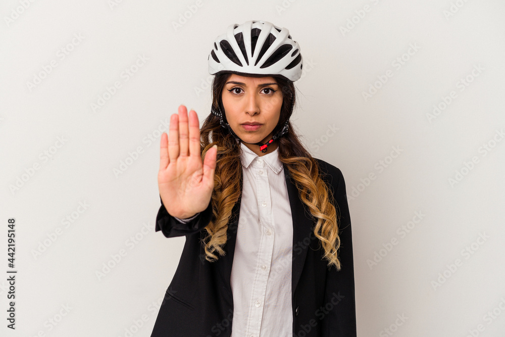 Young mexican woman riding a bicycle to work isolated on white background standing with outstretched hand showing stop sign, preventing you. Young mexican woman riding a bicycle to work isolated on white background standing with outstretched hand showing stop sign, preventing you.