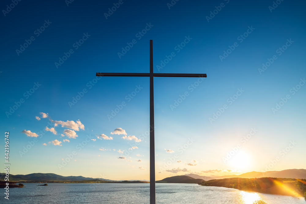 Christian cross against clouds and lake Christian cross against clouds and lake